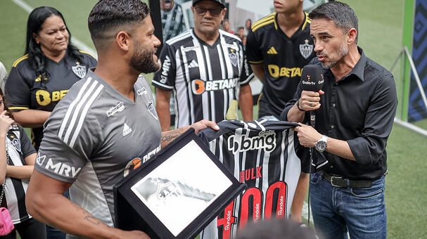 Rodrigo Caetano entregando uma placa comemorativa a Hulk